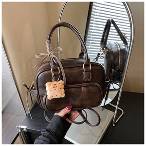 Détail du sac à main vintage marron foncé en similicuir avec ses accessoires et anses