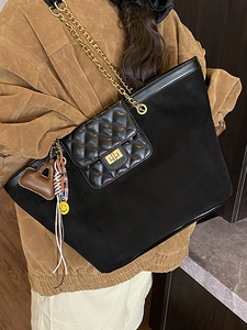 Women's black matte tote bag with diamond lattice pocket and gold chain strap on model