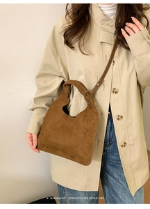 Minimalist brown suede shoulder bag with retro vibes and unique integrated cutout handle
