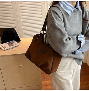 Dettaglio di una borsa tote leopardata marrone che mostra la texture scamosciata e il manico
