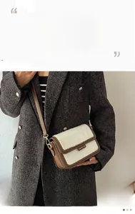 Détail d'un sac bandoulière bicolore en cuir marron et texture imitation fourrure blanche