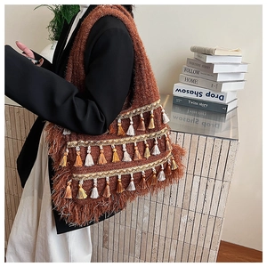 Detailed view of bohemian woven tote bag featuring colorful tassels and gold embroidery
