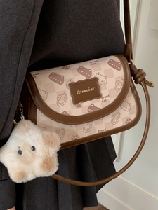 Vintage crossbody bag with cat print, star plush charm and flap closure on model