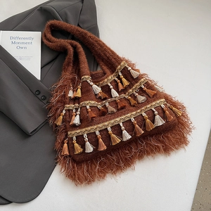 Close-up of bohemian brown knit tote bag featuring colorful tassels and fringe details