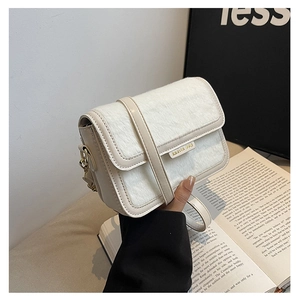 Détail du petit sac carré avec rabat en fausse fourrure et plaque de logo dorée