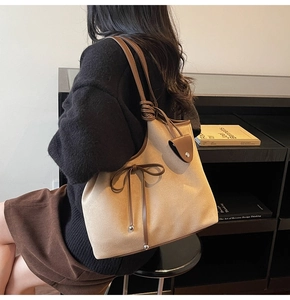 Close-up of retro large tote bag with ribbon bow detail and side pocket for women