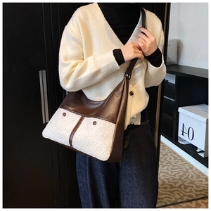 Detail view of the brown leather shoulder bag with white faux fur splicing on a model