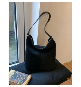 Detail of black suede Hobo bag with smooth shoulder strap and matte textured finish