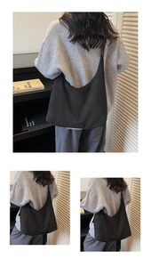 Detail view of a black minimalist matte hobo tote bag shown on a model in a home setting