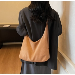 Close-up of brown suede tote bag showing soft texture and large hobo shape on shoulder