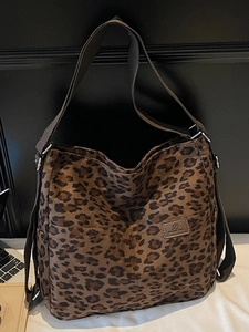 Close-up of leopard print tote bag featuring front dual pockets and adjustable strap