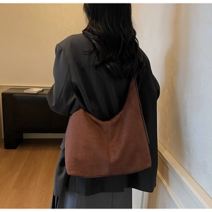 Detailed back view of a person wearing a large dark brown matte hobo shoulder bag
