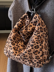 Detail of silver metal adjustment buckle on leopard print tote bag with black strap