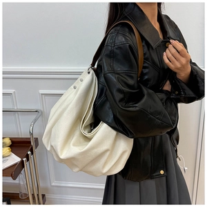 Lifestyle shot of a spacious off-white canvas hobo bag with brown leather shoulder straps