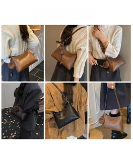 Detailaufnahmen der französischen Beuteltasche mit strukturiertem Leder und Pompon-Anhänger