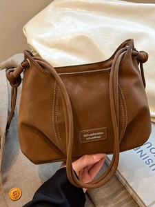 Chic dark brown vintage leather crossbody bag with contrast stitching and knotted strap detail