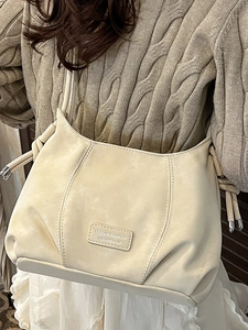 French vintage cream leather crossbody bag with knot details on a knit sweater model