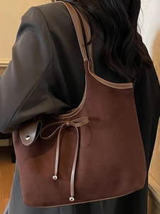 Large vintage matte tote bag in dark brown with bow detail on a shoulder model