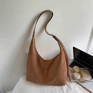Close-up of brown suede hobo tote with adjustable strap and matte texture details