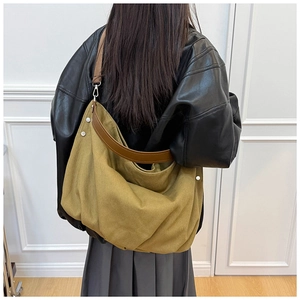 Detail view of khaki hobo tote with brown leather strap and silver rivet accents