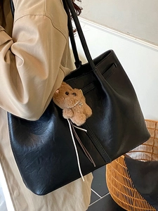 Minimalist large black tote bag in soft leather with a cute plush bear charm