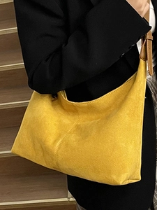 Retro mustard suede hobo bag with adjustable brown leather strap in a city commute style
