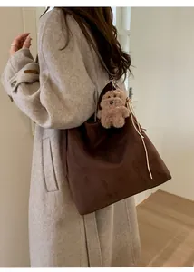 Vue détaillée du grand sac cabas en daim marron avec pendentif ours sur le mannequin
