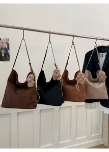 Détails des sacs à bandoulière en daim en marron, noir et beige avec pendentif ours