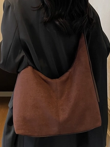 Minimalist large brown suede hobo tote bag for women shown as worn on shoulder