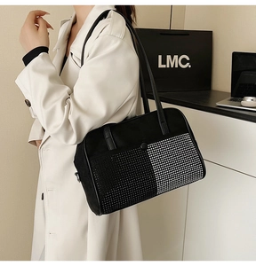 Détail du sac bandoulière noir avec clous en métal argenté et surface en tissu suédé texturé