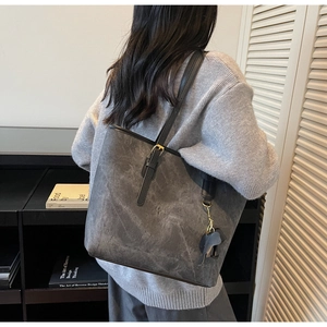 Detailed close-up of dark grey tote bag with marble texture and elegant gold hardware