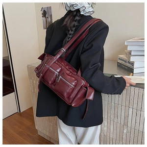 Detail of wine red crossbody bag with functional multi-pockets and silver zippers