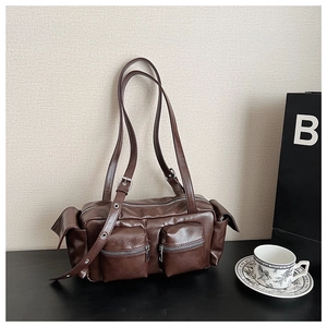 Detail of vintage dark brown PU leather shoulder bag with side pockets and silver hardware