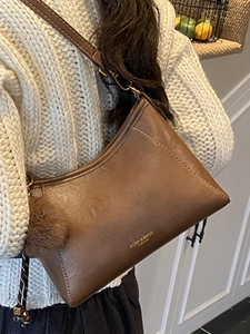 Retro braune Eimertasche aus PU-Leder mit goldenem Logo und Plüschball-Anhänger für Damen
