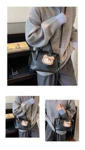 Detail of black faux leather Boston bag with a cute plush bear and bow charm