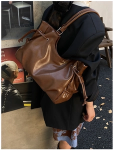 Detail of coffee brown oversized PU leather hobo bag showing oily luster and drawstring