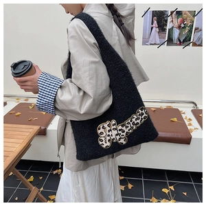 Detail of black teddy plush tote bag with leopard print letter patch on shoulder