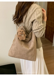 Détail du sac seau vintage en daim avec un charmant ours en peluche et perles