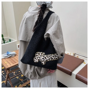 Detail of black teddy plush tote bag featuring leopard print Mama embroidery in autumn setting