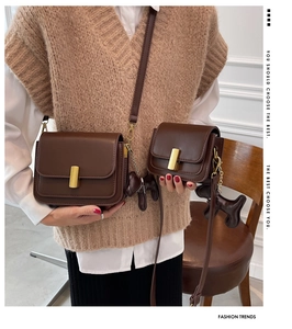 Détail de sacs bandoulière marron en deux tailles avec boucles métalliques dorées
