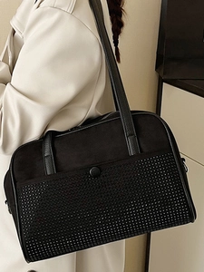Grand sac à épaule noir chic avec détails rivetés et finition suédine sur un modèle