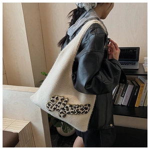 Detail of white knit tote bag featuring a Mars leopard print patch and soft texture