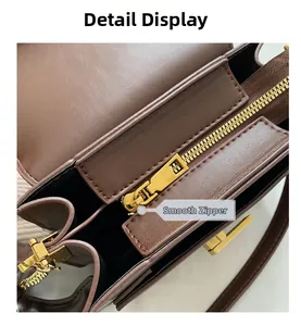 Détail du zip doré fluide et du cuir grainé sur un sac à main vintage marron