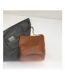Detail der dunkelbraunen Tragetasche mit verstellbarer Metallschnalle und Retro-Finish