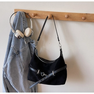 Détail du sac à épaule en daim noir avec boucle argentée et design de style hobo
