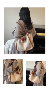 Détails du grand sac cabas en daim avec garniture en cuir et breloque pompon élégante