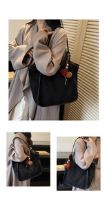 Vue détaillée du grand sac cabas en daim noir avec breloque pompon coloré et perles en bois