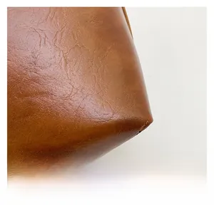 Detailansicht der braunen Ledertasche mit Kieselstruktur und hochwertiger Nähtechnik