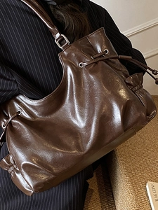 Vintage dark brown faux leather shoulder bag with drawstring detail and glossy finish