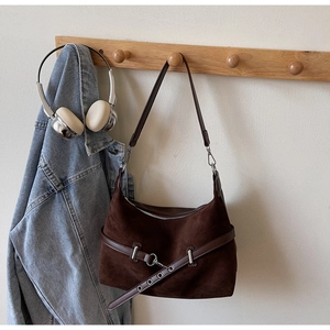 Détail d'un sac à bandoulière Hobo rétro en suède avec des boucles en métal argenté